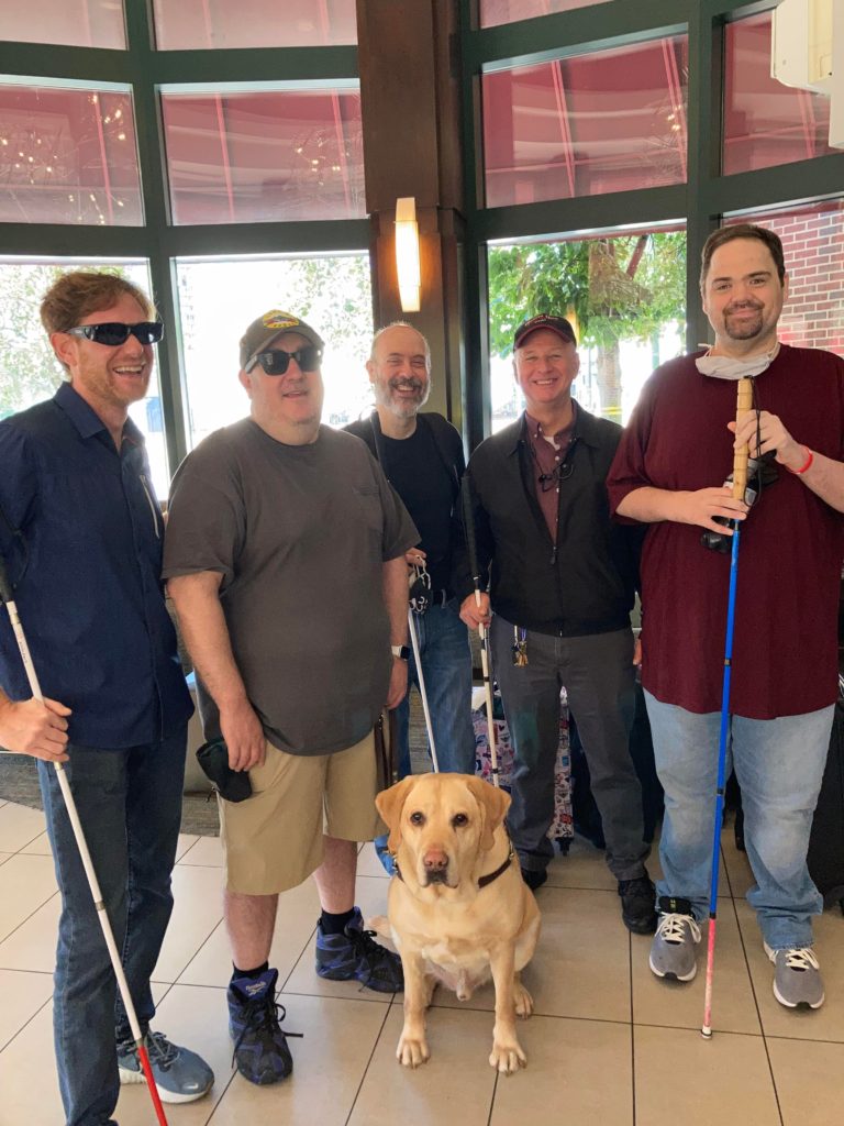 From left to right, Nick, Brian, David, Ed, and Dominic. Wes, Brian's guide dog is centered in front of the group. The morning after drafting The All Blind Fantasy Football League Year 6 in person for the Yahoo mini documentary. 
